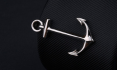 Silver anchor-shaped pendant with a polished reflective finish included in the men’s airplane tie clip and lapel pin gift set.