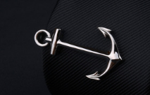 Silver anchor-shaped pin with a polished reflective finish from the men’s airplane tie clip and lapel pin gift set.