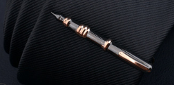 a sleek black and gold pen with a polished metallic finish featured in a men’s airplane tie clip and lapel pin gift set
