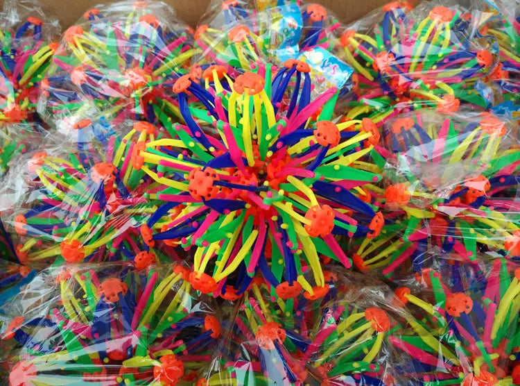 Jouet araignée en plastique multicolore et éclatant, avec des pattes orange vif, vert, jaune et bleu, intégré au jouet de balle magique à expansion, en sphère télescopique colorée.