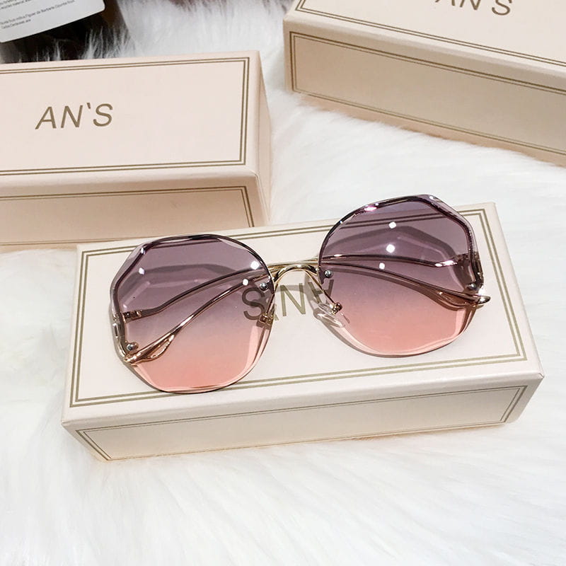 Sonnenbrille mit übergroßem, geometrischem Gradientendesign, mit Roségold-Metallrahmen und pink-violetten Gradientenlinsen.