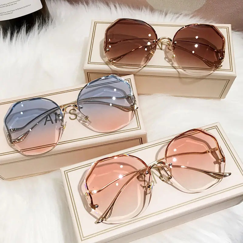 Set of three gradient oversized geometric sunglasses with gold-tone metal frames featuring brown to transparent blue to pink and peach to clear color transitions.