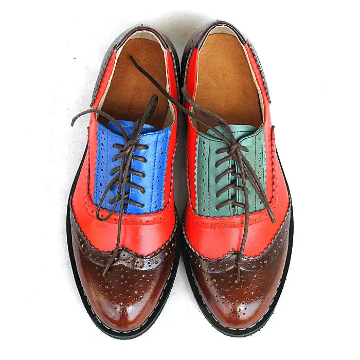 Leather oxford brogue shoes womens two tone flats featuring vibrant multicolored leather with bold red upper blue and green accents brown perforated toe caps and dark laces.