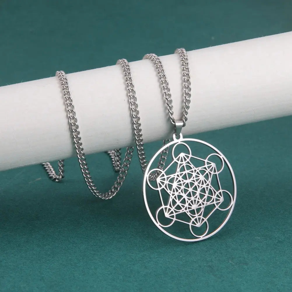 Silver geometric pendant necklace featuring a circular intricate metal design with intersecting lines and shapes made of stainless steel in the Metatron Cube moon goddess collection.