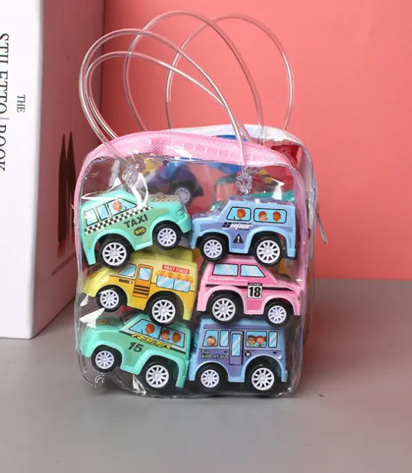 a clear plastic gift bag with pink handles filled with colorful miniature pull back fire truck and engineering vehicle toy set cars in various designs and vibrant hues