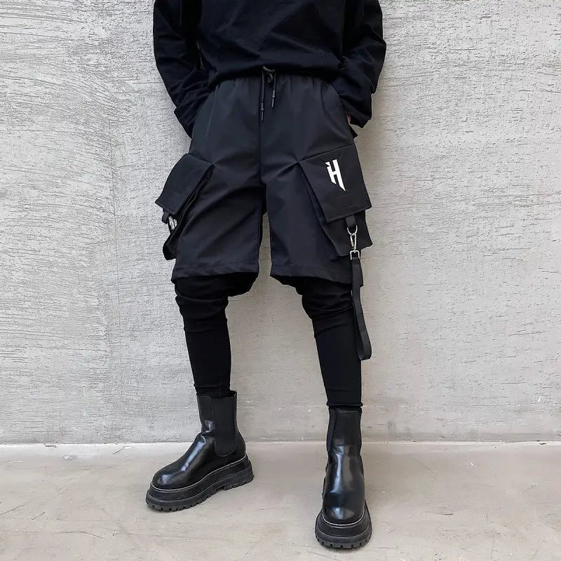 black tactical cargo shorts with multiple pockets and a white h logo on the thigh designed with a detachable strap for hip hop style.