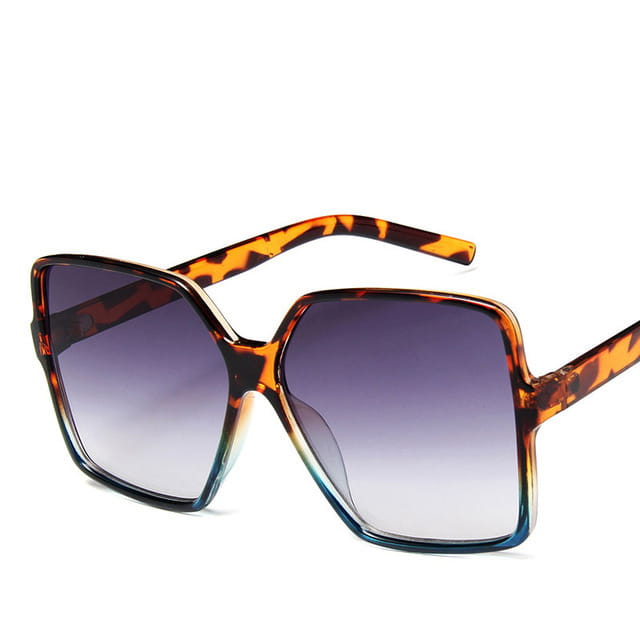 Gafas de sol vintage geométricas extragrandes con protección UV400 y lentes con degradado, con montura cuadrada con patrón carey y lentes de color púrpura a transparente.