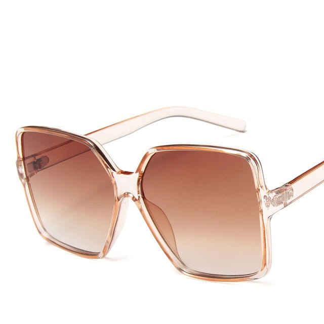 Gafas de sol vintage geométricas extragrandes con protección UV400 y lentes con degradado, con montura transparente en tono oro rosa y lentes marrones con degradado.