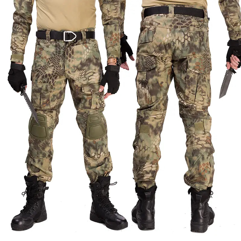 Pantalon tactique avec genouillères et poches cargo présentant un motif camouflage écaille de serpent dans des verts et bruns terreux, avec une protection des genoux renforcée et plusieurs compartiments de rangement.