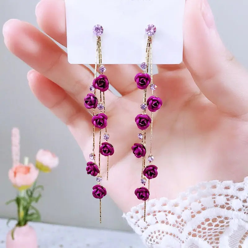 Elegant purple rose tassel drop earrings with gold-toned chains clear crystal accents rhinestones and pearls.