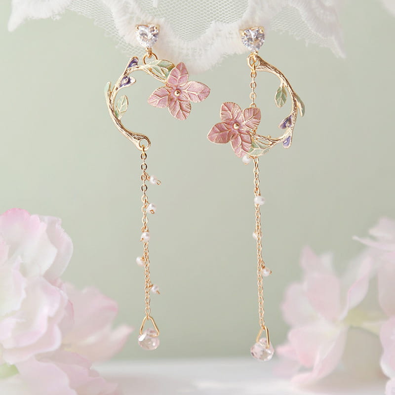 Elegant rose tassel drop earrings featuring delicate gold-toned metal with pink enamel flowers and rhinestones, crescent-shaped vine accents, and pearl-like beads ending in clear teardrop charms.