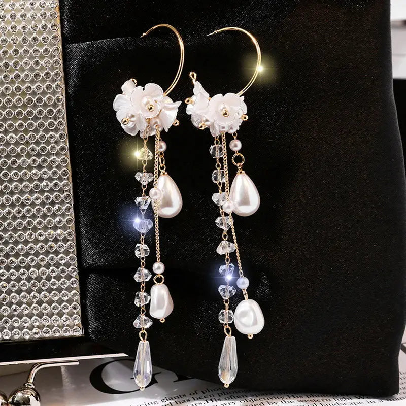 Elegant white floral hoop earrings featuring dangling pearls crystal drops and gold-toned accents inspired by rose tassel drop earrings with rhinestones and pearls.