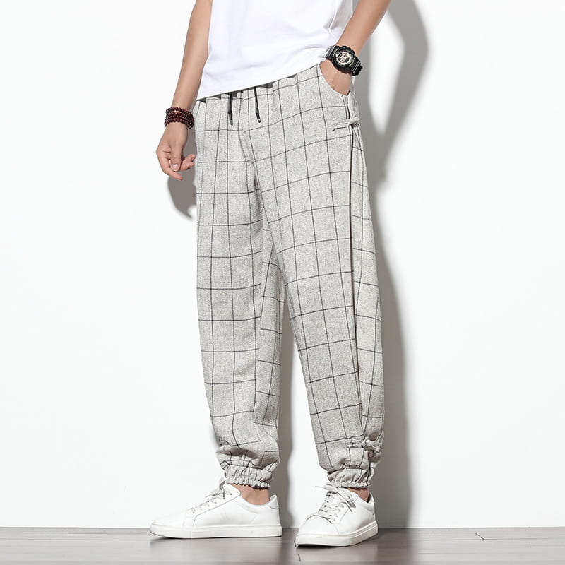Men plaid harem pants featuring gray jogger style with black grid pattern and elastic cuffs for a loose casual cropped fit