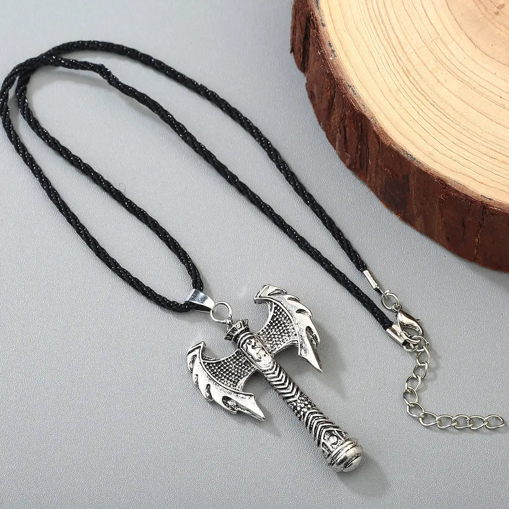 Silver intricate Viking axe pendant necklace featuring a detailed axe-shaped pendant on a black braided cord