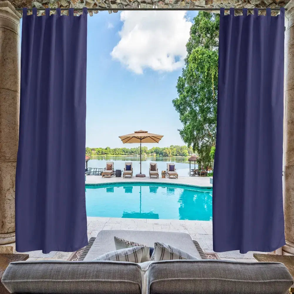 deep navy blue waterproof outdoor curtains with reinforced grommets hang from stone pillars framing a swimming pool and lounge area in a 50x96 size.