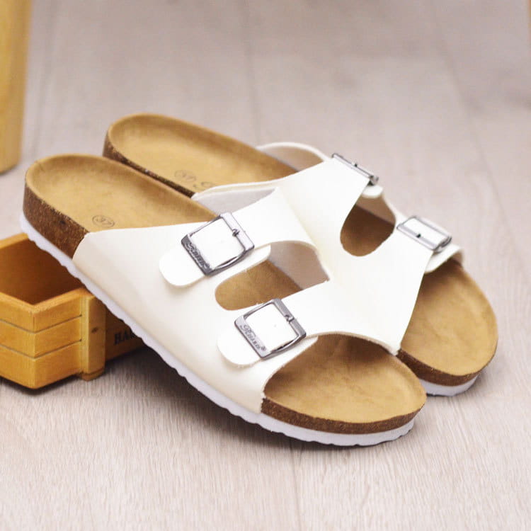 white birkenstock cork footbed leather two strap sandals with silver buckle straps and cork footbed viewed from the back