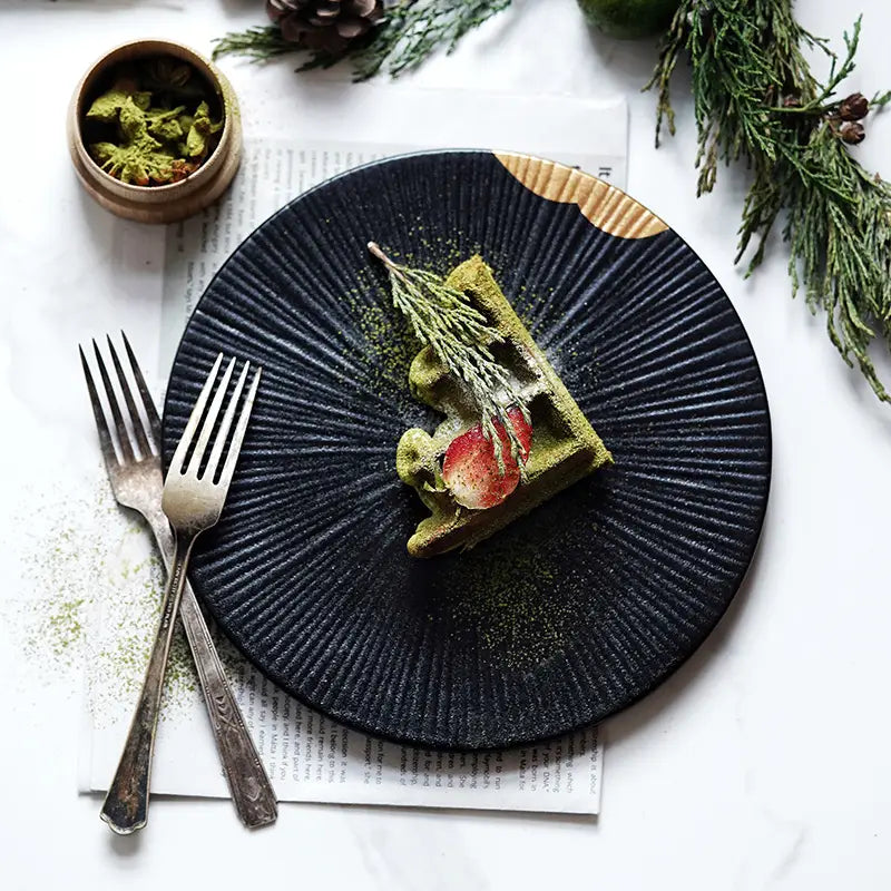 Assiette en céramique bleu foncé avec des rainures radiales et un accent de bord en bois, agrémenté de détails dorés et d’accents de bord en bois.