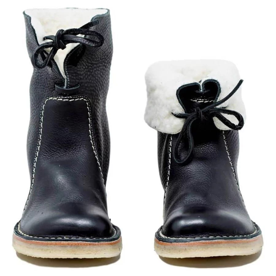 Black leather women’s martin boots with white shearling lining and black laces designed for warmth and style.