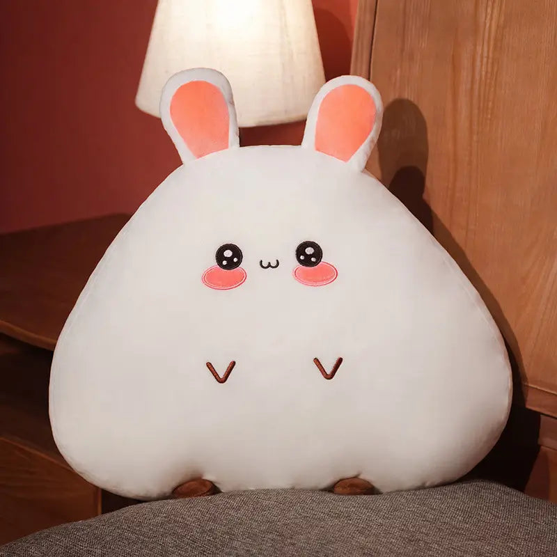 Ein weiches weißes Kuschelhasen-Kissen mit pinkfarbenen Innensohrchen, bestickten schwarzen Augen, rosigen Wangen und einem braun angenähten V-förmigen Mund; erhältlich in den Größen 45 cm und 65 cm.