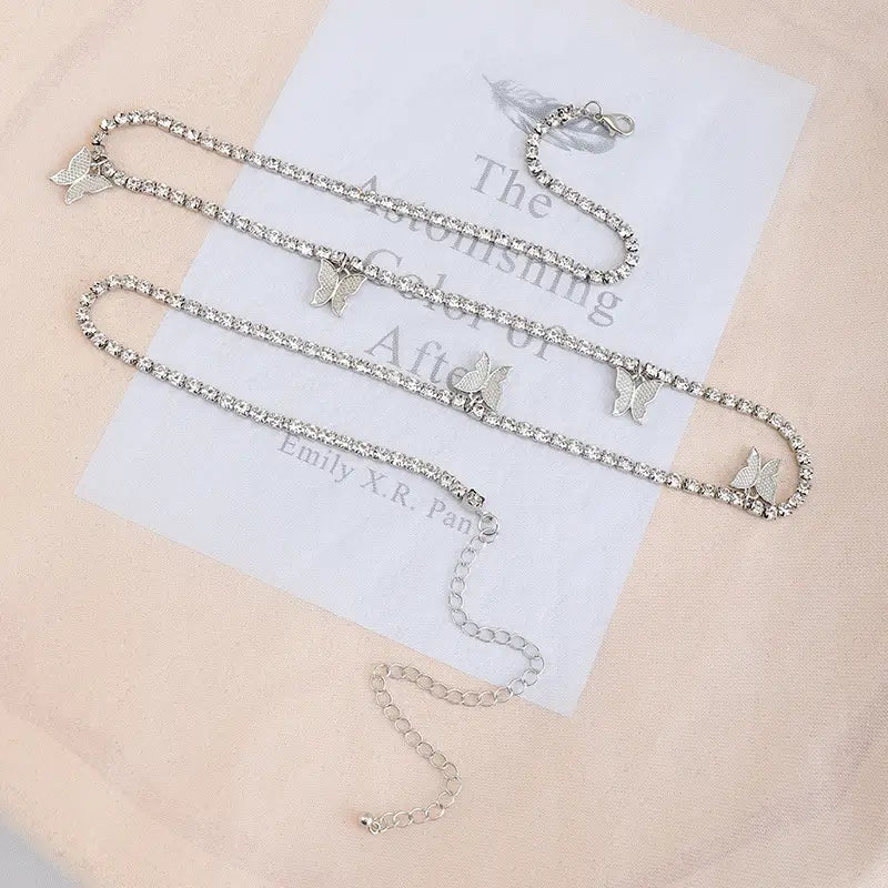 Silver rhinestone butterfly anklet with adjustable chain and clasp featuring sparkling rhinestone accents for elegant wear.