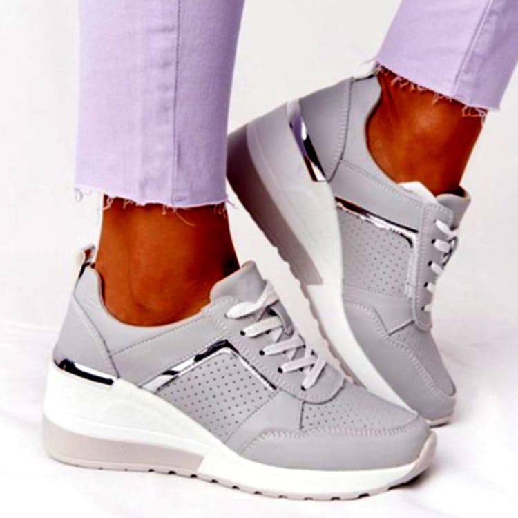 Gray platform wedge sneakers mesh with white laces and metallic silver accents on the sides for casual wear.