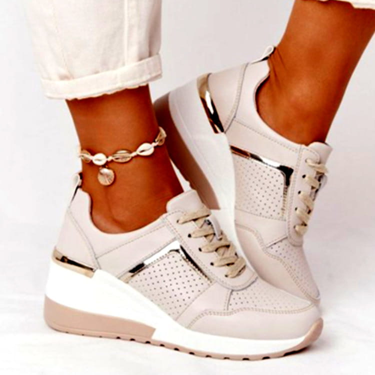 Beige platform sneakers with metallic gold accents and perforated mesh panels featuring a wedge lace up design for casual wear.
