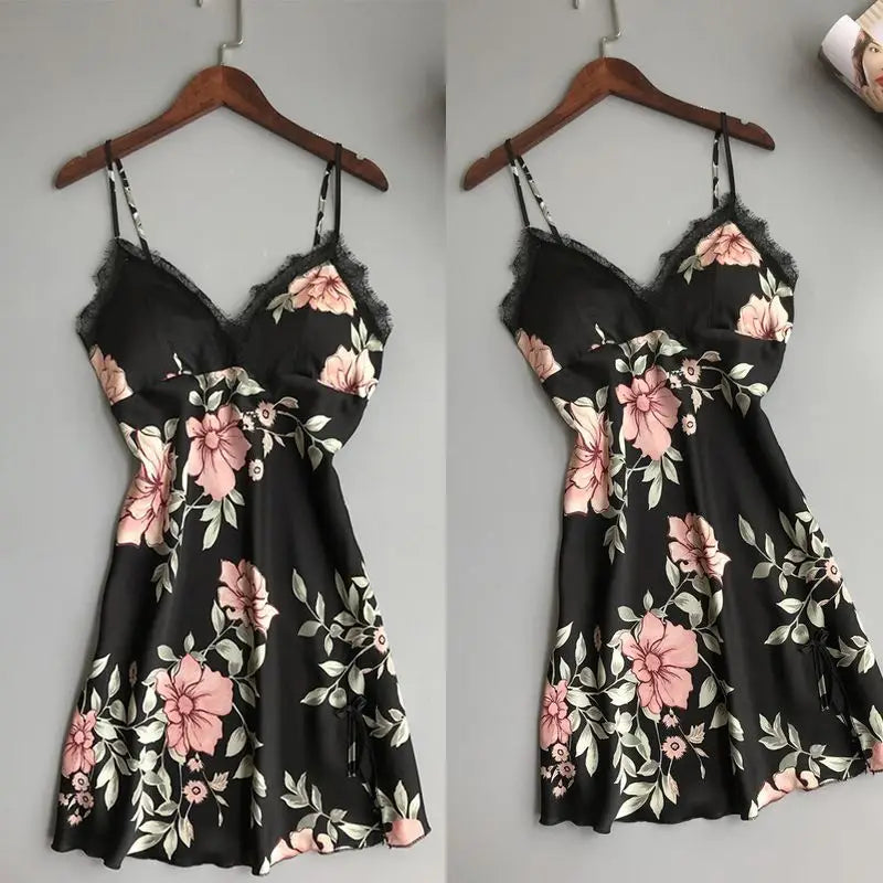 ピンクとホワイトのフローラルプリント、ならびにレースのトリムをあしらった黒のサテン製スリップドレス。フローラルレースのサテン製ナイトガウンのシルクスリープウェアのスリップドレスとしてデザインされています。