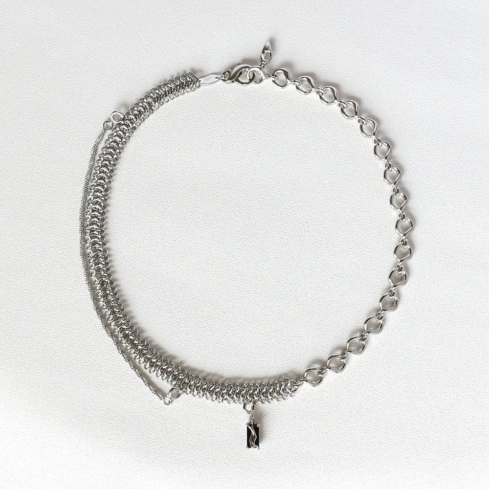 Textured heart link silver necklace with layered design featuring heart-shaped links and a small black rectangular charm pendant.