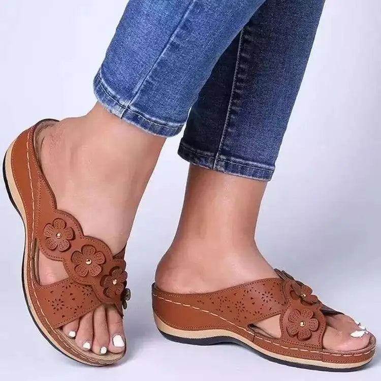 Des sandales compensées et des mules en cuir marron à motif floral rétro, dotées de détails découpés floraux et de clous décoratifs.