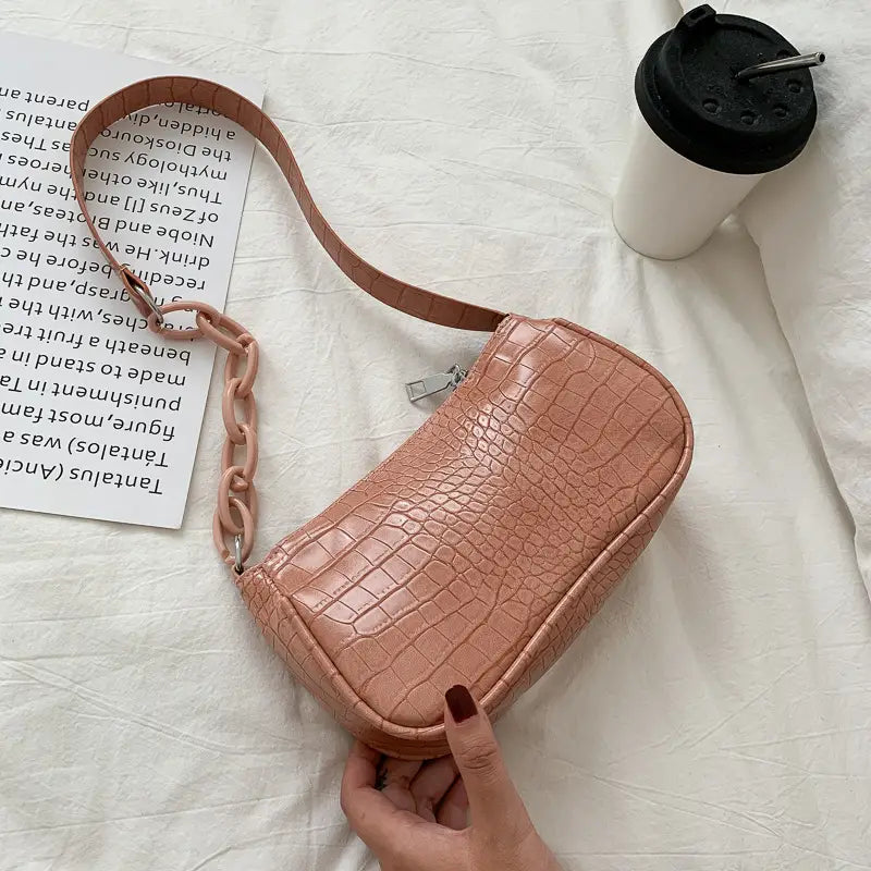 A blush pink croc embossed chain shoulder bag for women with a croc embossed texture and a chain strap.