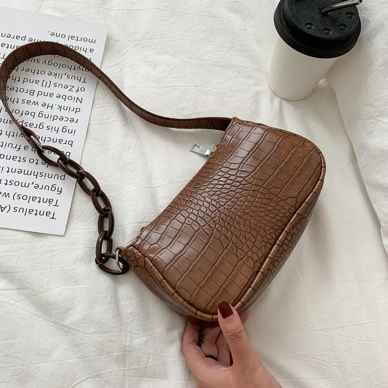 Brown croc embossed chain shoulder bag for women featuring a crocodile textured leather material and a chunky chain strap.