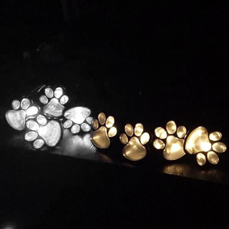 Glänzende, metallische, pfotenförmige Solar-LED-Leuchten für den Außenbereich zur Dekoration von Gartenwegen in silbernen und goldenen Farbtönen.