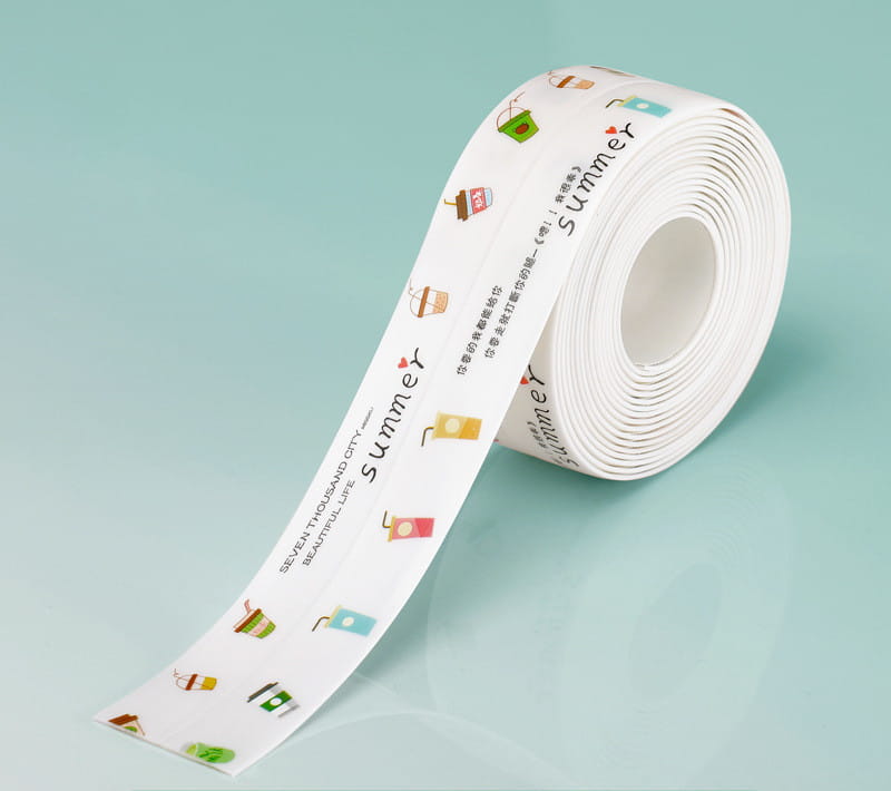 Un rouleau de ruban adhésif d’étanchéité pour cuisine en PVC blanc, imperméable et anti-moisissure, présentant des illustrations et du texte à thème estival colorés.
