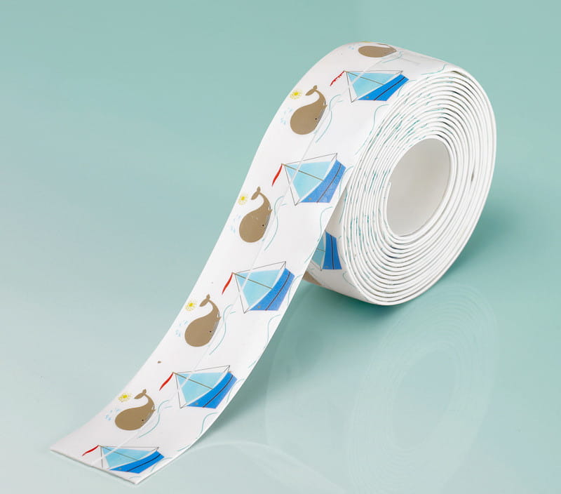 Un rouleau de ruban adhésif d’étanchéité pour cuisine en PVC blanc, anti-moisissure, avec une bande d’étanchéité imperméable, présentant un motif ludique de cerfs-volants bleus et de baleines brunes.