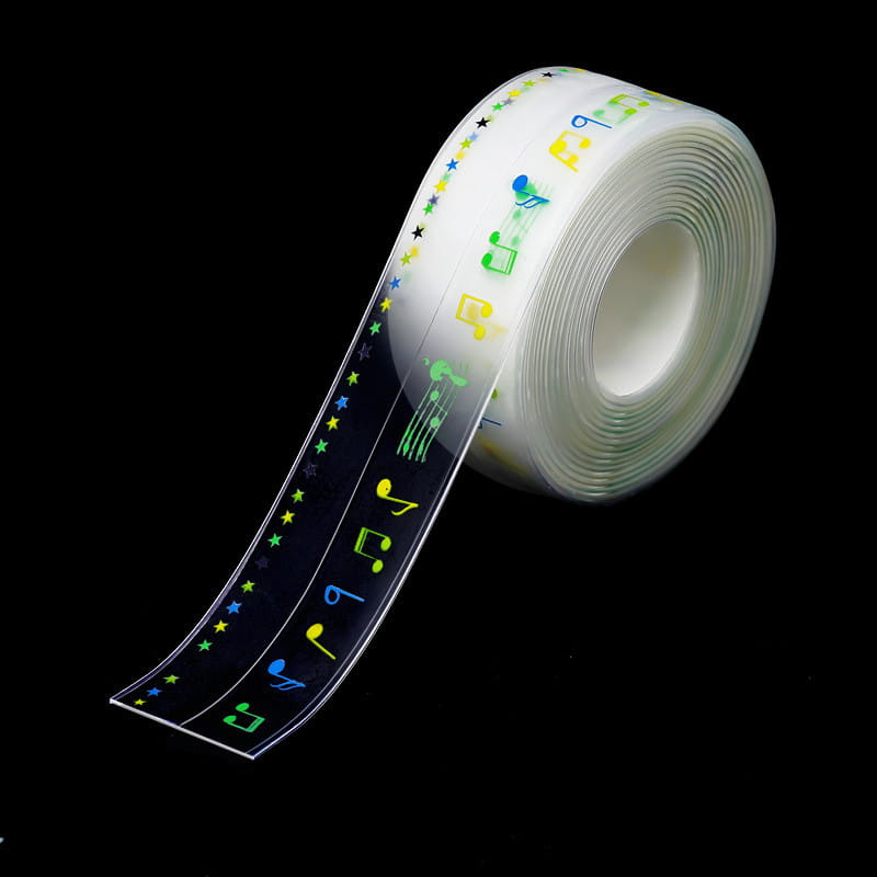 Rouleau de ruban adhésif clair, avec des notes de musique et des étoiles colorées en vert, jaune, bleu et noir, conçu comme un ruban d’étanchéité anti-moisissure pour cuisine en PVC imperméable.
