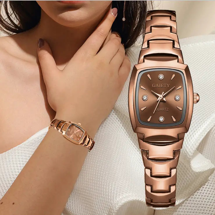 Montre rectangulaire élégante en quartz rose gold avec des accents en forme de diamants sur la lunette et les index des heures, accompagnée d’un bracelet maillon assorti en rose gold.