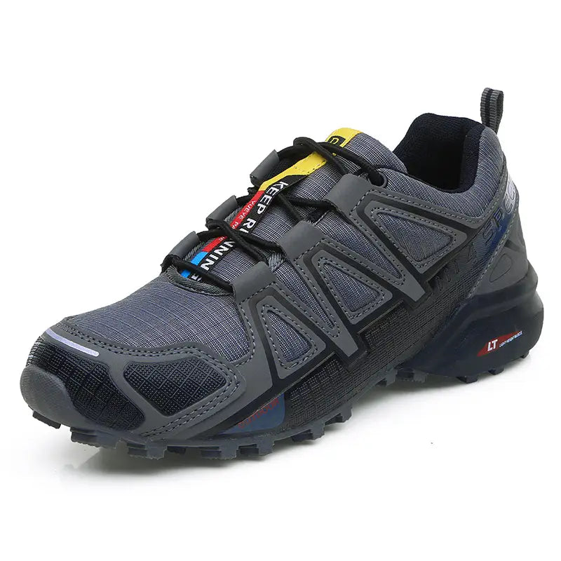 Men’s rugged breathable trail running and hiking shoe in gray with black accents featuring a yellow and red lacing system and a textured rubber outsole.
