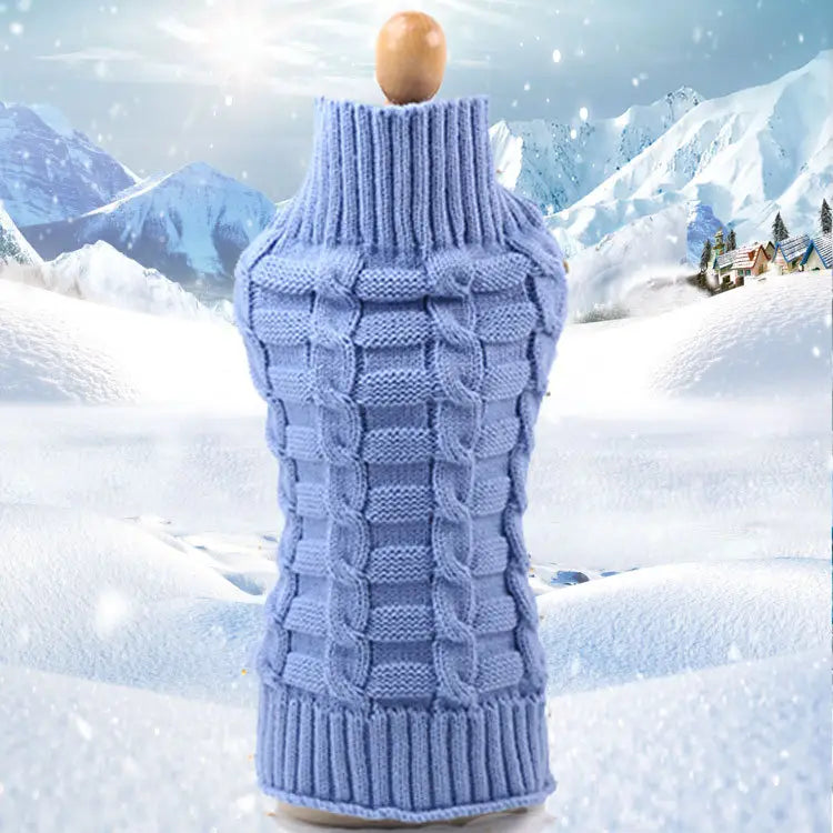 Un pull pour chien en cachemire bleu clair, à col haut, avec un motif de torsades en câble tricoté complexe, présenté sur un mannequin en bois.
