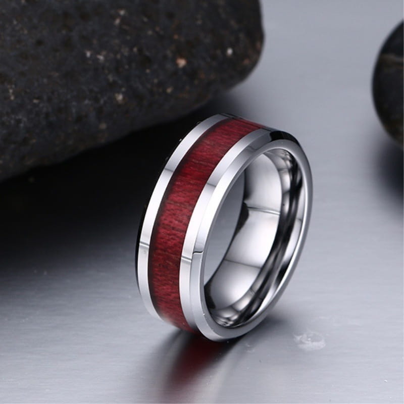 A sleek silver tungsten ring with a vibrant red wood and zircon inlay featuring polished metallic edges in a couple wedding ring set.