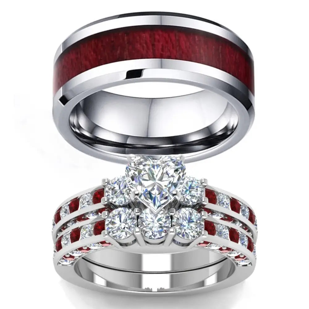 Silver wedding ring set featuring a bold red wood inlay and intricate design with heart-shaped and round-cut clear gemstones accented by vibrant ruby stones in the red wood and zircon inlay couple wedding ring set.