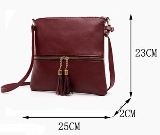 Un sac bandoulière en simili cuir bordeaux avec fermeture éclair à finition ton sur ton doré et détail de pompon.