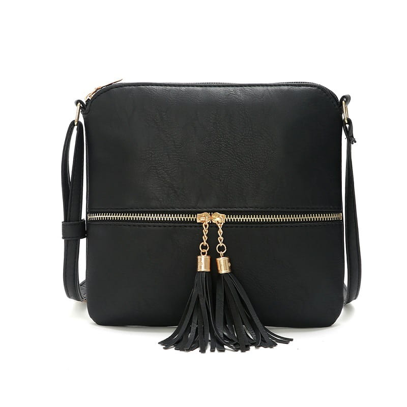 Un sac bandoulière à pompon en simili cuir noir avec finition texturée et détail de fermeture éclair à finition ton sur ton doré, ainsi qu'un pompon décoratif noir sur la fermeture avant.