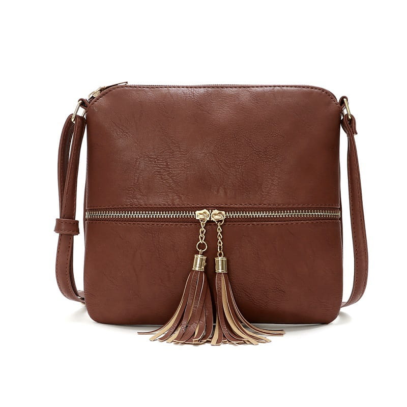 Un sac bandoulière en simili cuir marron avec fermeture éclair à finition ton sur ton doré et pompons assortis, incluant un détail de fermeture éclair pour un rangement sécurisé.