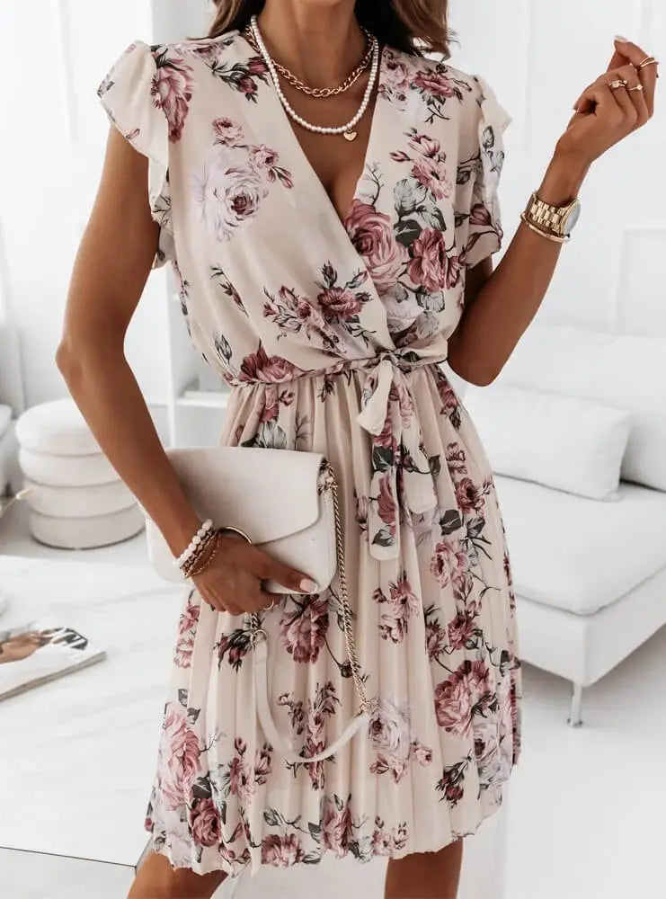 A soft beige floral ruffle wrap dress with short sleeves and a pleated skirt featuring pink and burgundy rose patterns.