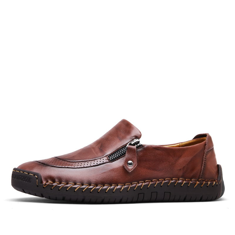 Des mocassins en cuir marron pour hommes, avec fermeture éclair, et des détails de surpiqûres visibles, conçus pour un usage affaires-décontracté.