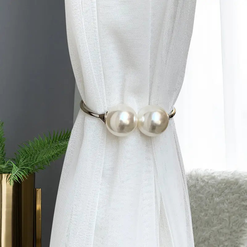 Pearl curtain tieback featuring two lustrous white pearls set in a sleek silver alloy spring buckle frame for elegant window decoration.
