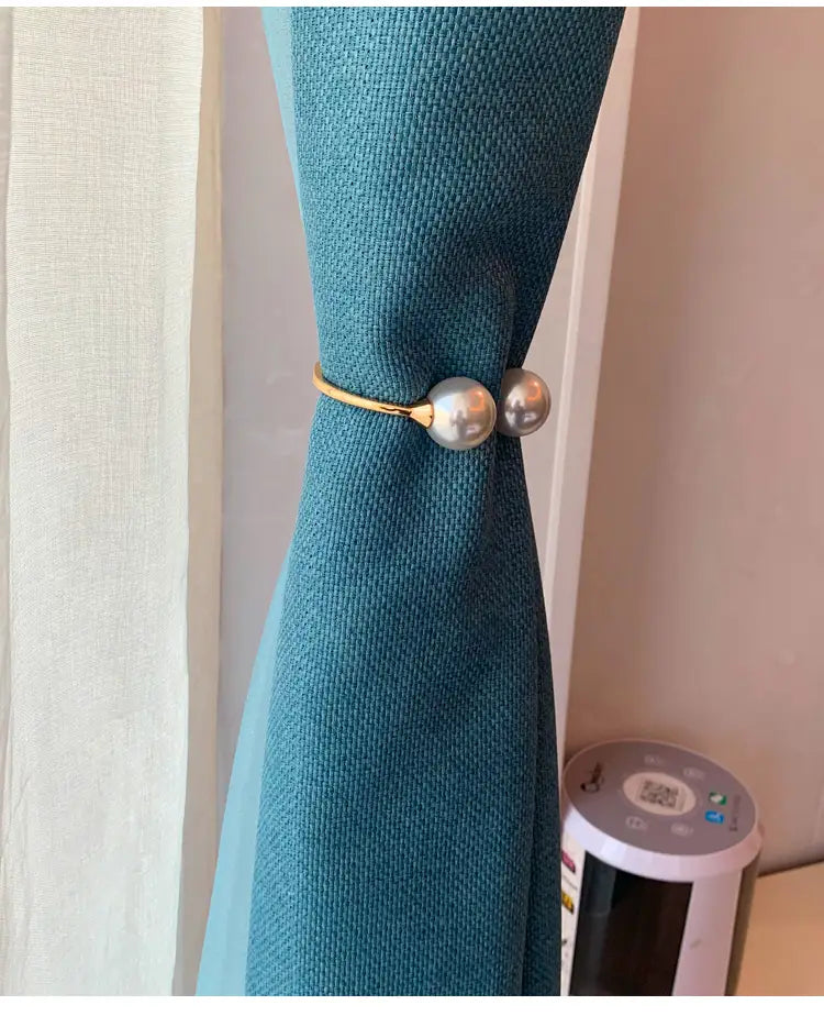 Gold-toned pearl curtain tieback featuring two round lustrous beads and an elegant alloy spring buckle for decorative window treatment.