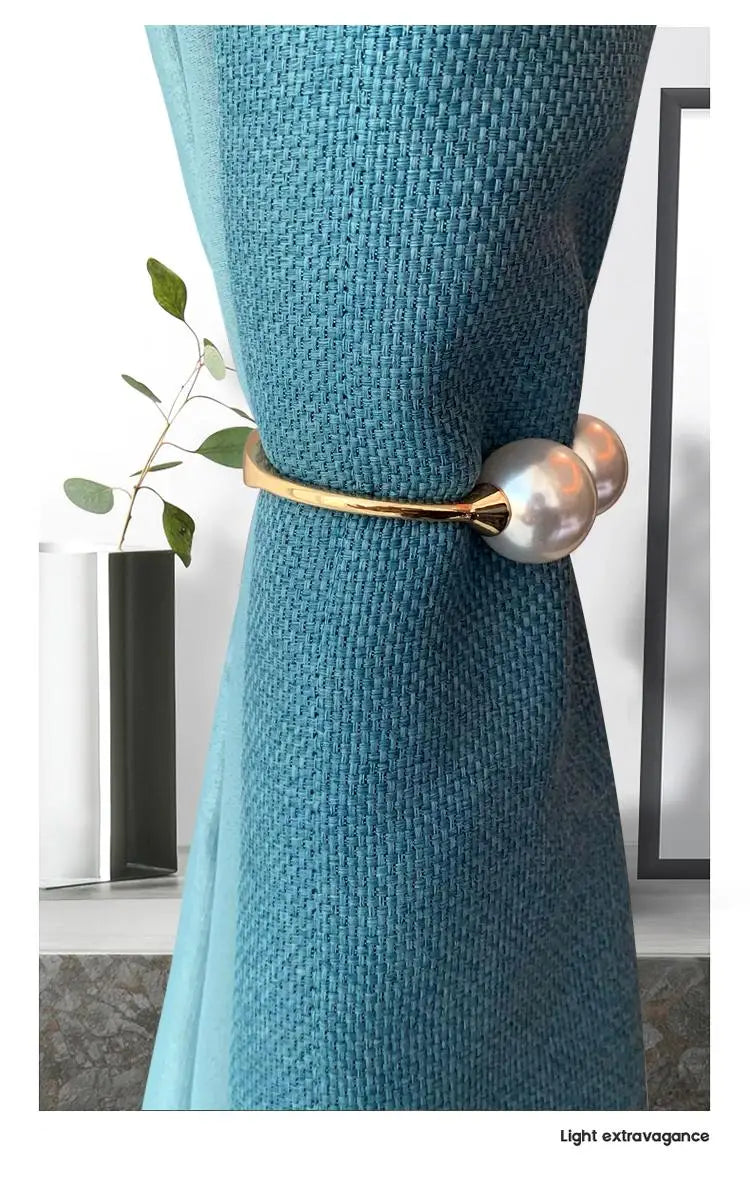 Gold-toned curtain tieback with two pearl-like spheres made of elegant alloy spring buckle for stylish window decor.