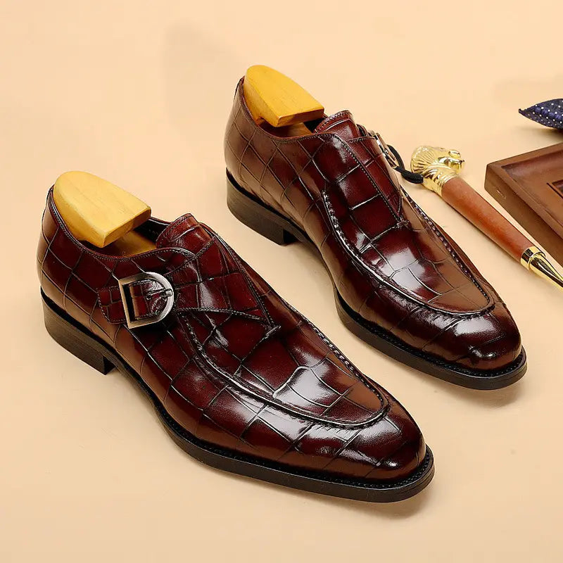 Classic men’s leather formal dress loafers in burgundy crocodile-embossed leather with silver monk strap buckle.