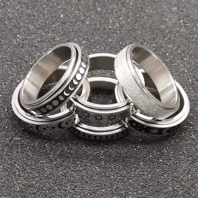 Set of silver-toned stainless steel anxiety spinner rings with moon and star motifs.
